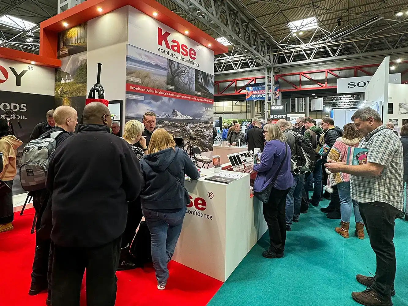 The picture captures the busy scene at Kase’s exhibition booth—many visitors are moving around, visiting the booth to learn about Kase’s photography accessories.
