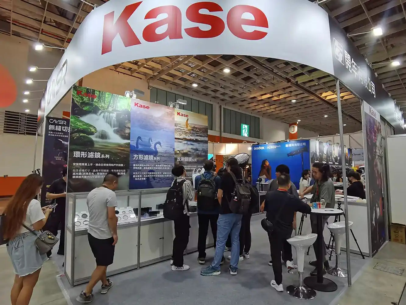 Kase booth at an exhibition with people around